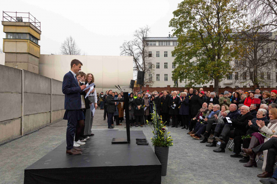 Drei Jugendliche halten eine Rede vor großem Publikum an der Gedenkstätte Berliner Mauer.